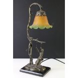 Art Nouveau style bronze table lamp in the form of a woman on a swing, with a green & orange mottled