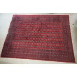 Red ground Bokhara pattern carpet with eleven rows of guls within a border, approx. 358cm x 270cm