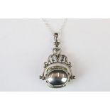 A silver revolving photo fob locket on silver chain.