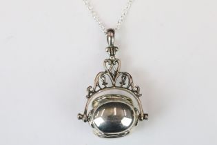 A silver revolving photo fob locket on silver chain.