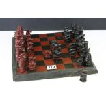 African carved wood chess set having carved hard wood pieces complete with board. Tallest piece