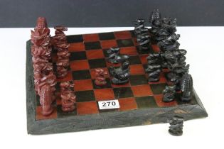 African carved wood chess set having carved hard wood pieces complete with board. Tallest piece