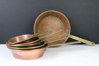 Set of Seven Copper Graduating Frying Pans with brass handles, largest approx 20cm diameter