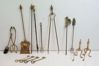 Group of brass fire irons to include assorted tongs, poker, brush fire dogs, ornamental keys etc.