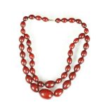 Early 20th century cherry amber Bakelite bead necklace, forty-five graduated oval beads the
