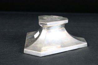 Silver desk inkwell of triangular shape with truncated corners, flared faceted body, the hinged