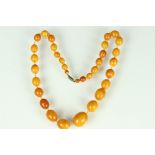 Early 20th century Butterscotch amber bead necklace, thirty-three graduated oval and circular beads,