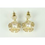 Pair of Chanel costume jewellery earrings having crossed C's to the heads with floral drops