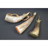 A collection of three carved horn powder flasks with brass fittings.