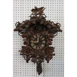 Early 20th Century carved black forest cuckoo clock having carved wooden birds and vine leaves to