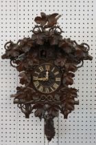 Early 20th Century carved black forest cuckoo clock having carved wooden birds and vine leaves to