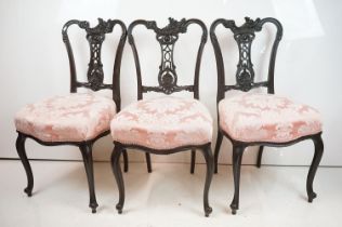Set of Four Victorian Dining Chairs with ebonised carved frames and pierced splats, the stuff-over