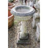 Reconstituted stone garden urn, the bowl of shallow form, raised on a baluster column base. (