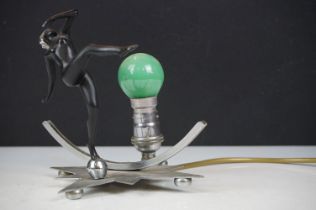 Art Deco wall lamp having a star shaped back plate with a nude female figure and green light bulb.