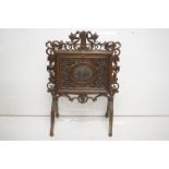 19th century Black Forest MagazineRack, the frame with heavy naturalistic scrolling foliate carving,