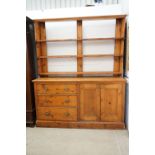 19th century Pine Dresser, the upper section with three open plate shelves having hooks, the lower