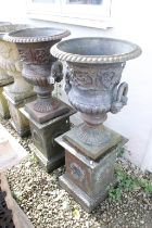 Pair of twin-handled cast iron garden urns, with relief scrolling floral & acanthus detail,