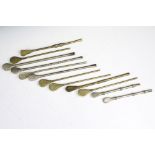 A collection of twelve vintage mate spoons to include brass and white metal examples.