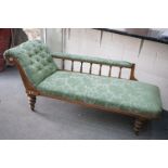 Victorian Walnut Framed Chaise-lounge with green button back upholstery, raised on turned legs