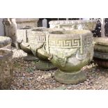 Set of three reconstituted stone planters with Greek key and grape decoration, raised on circular