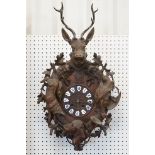 19th Century carved black forest pendulum wall clock having a round clock to the centre with