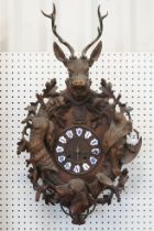 19th Century carved black forest pendulum wall clock having a round clock to the centre with