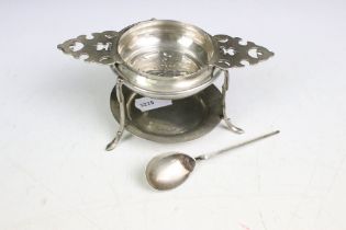A fully hallmarked sterling silver tea strainer together with silver stand and spoon.