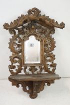 Black Forest Walnut Hanging Hall Mirror and folding Shelf, carved with foliate scrolls, 59cm high