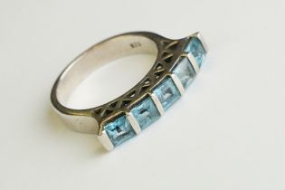 A silver dress ring set with five blue stones.