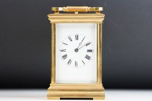 A brass cased carriage clock with bevelled glass panels, with hourly repeater button to the top.