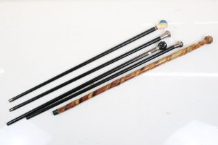 Group of five wooden walking sticks, to include two early 20th century ebonised examples with silver