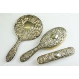 A fully hallmarked sterling silver vanity hand brush and mirror set with floral and green man