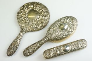 A fully hallmarked sterling silver vanity hand brush and mirror set with floral and green man