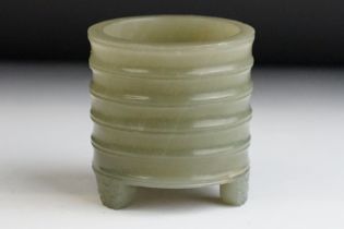 A Chinese antique jade three footed brush pot with ribbed decoration.