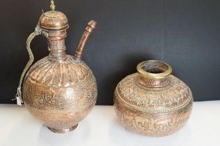 A large Iranian copper ewer jug with ornate decoration and brass fittings together with a similar