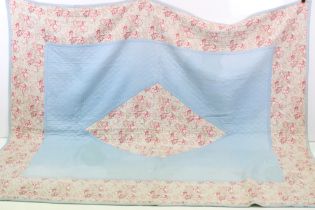 Mid 20th Century quilt having a pink and green floral paisley style print with stitched label marked