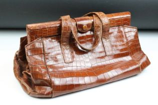 Vintage crocodile leather handbag with twin carry handles, the internal pockets housing a powder