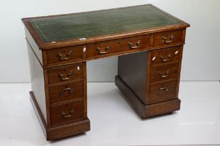 Victorian Oak Twin Pedestal Desk, the green leather inset top over an arrangement of nine drawers,