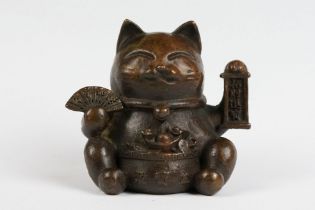 An ornamental Japanese bronze 招き猫 / maneki-neko (waving / beckoning) lucky cat talisman.