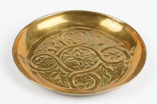 A Keswick school of arts brass dish with traditional decoration.