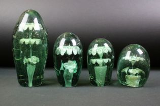Four 19th Century Victorian dump glass paperweights each having two tiered floral inclusions.