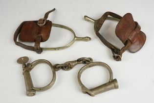 A pair of antique handcuffs complete with key together with a pair of spurs.