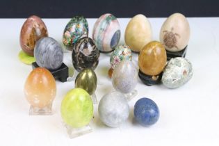 A collection of decorative ornamental eggs to include polished stone and lacquer ware examples.