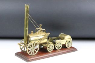 Brass mounted model steam engine featuring a trailer to the back laden with coal. Mounted on a