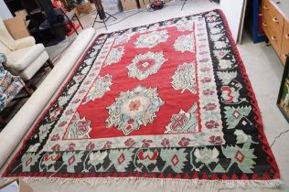 Kilim Gocmen Rug, the red ground decorated with medallions within a black border, 331cm x 224cm