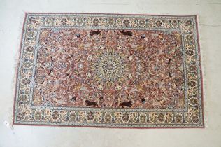 Persian style Rug, the pink ground with a pattern of stylised hunting big cats and deer with birds