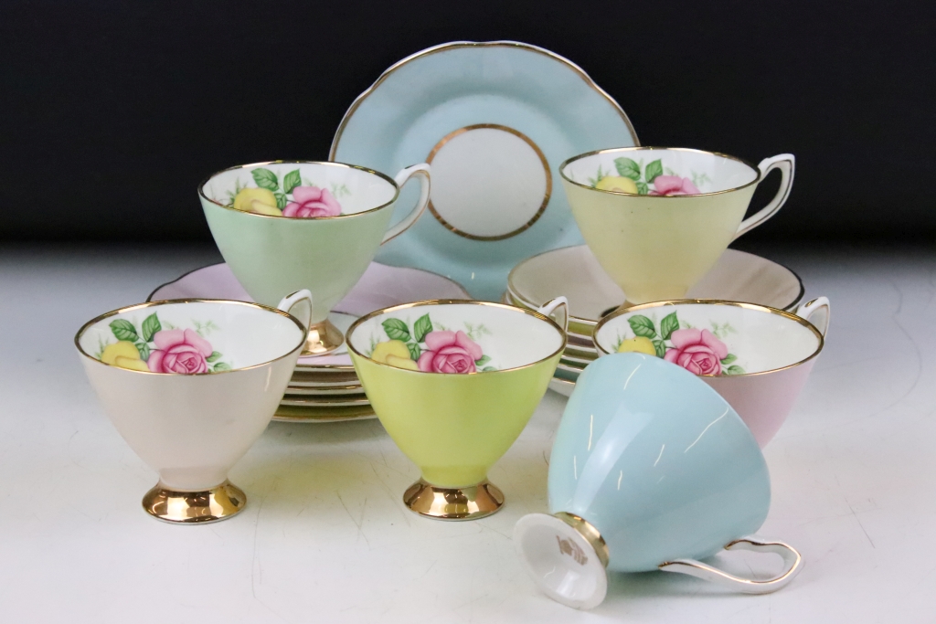 Set of six Cavour Ware trios, each with printed roses to the inside of the cups and gilt rims. All