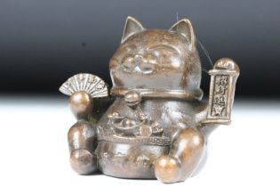 An ornamental Japanese bronze 招き猫 / maneki-neko (waving / beckoning) lucky cat talisman.