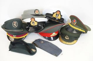 A collection of ten military caps and berets together with associated badges to include Ukraine