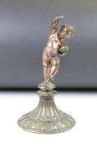 Antique cast bronze putti figurine depicting a classical putti with symbols raised on a fluted